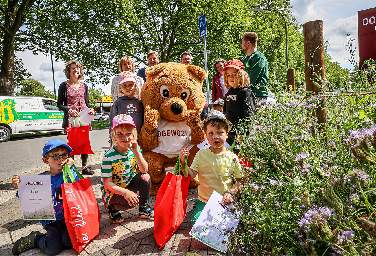 Kinder und DOGEWO21-Mitarbeitende bei der Wildblumenwiese-Aktion.