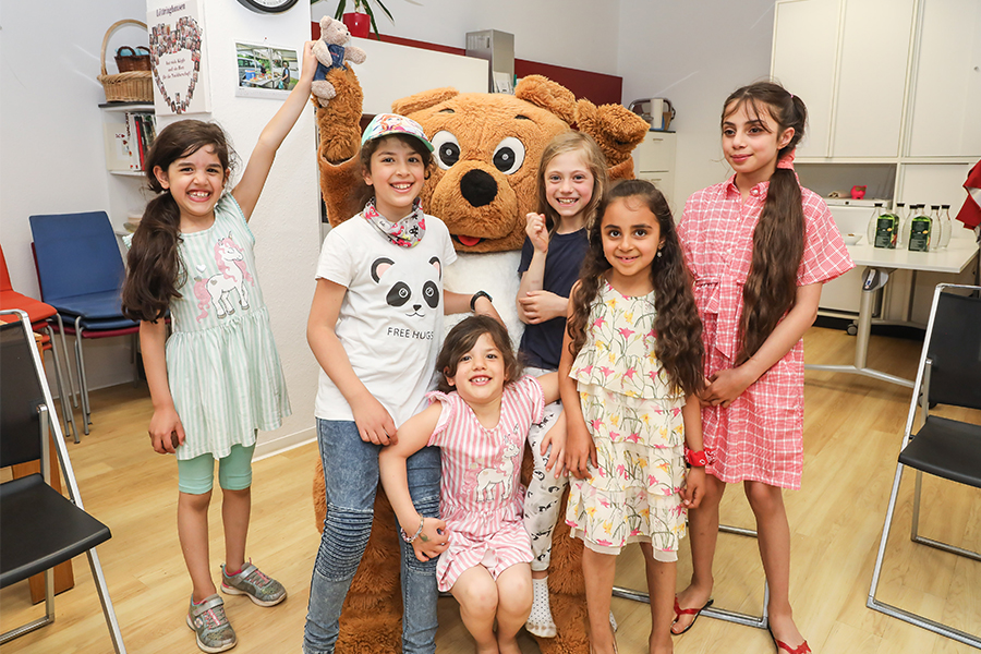 Gruppenfoto einiger Kinder der DOGEWO21-Kinderrallye zusammen mit Dogibär.