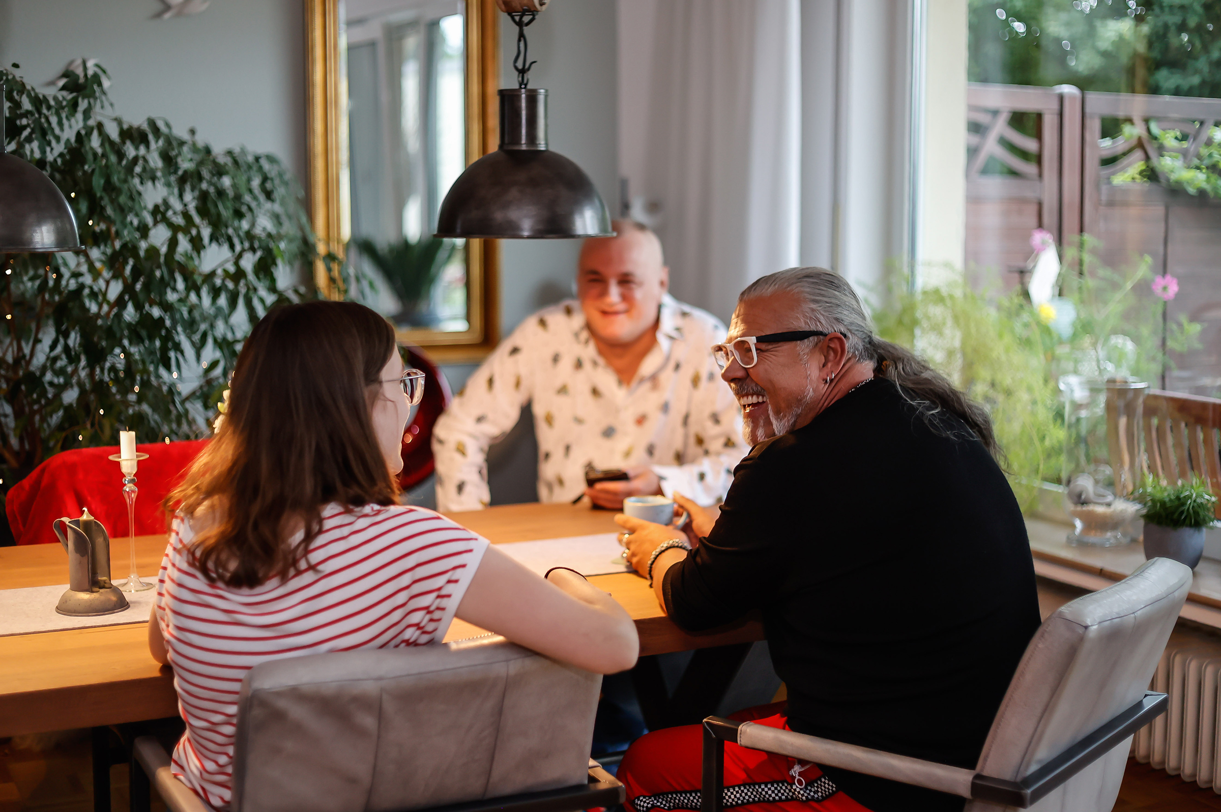 Gemütliches Zusammensitzen dreier Nachbarn beim Kaffee.