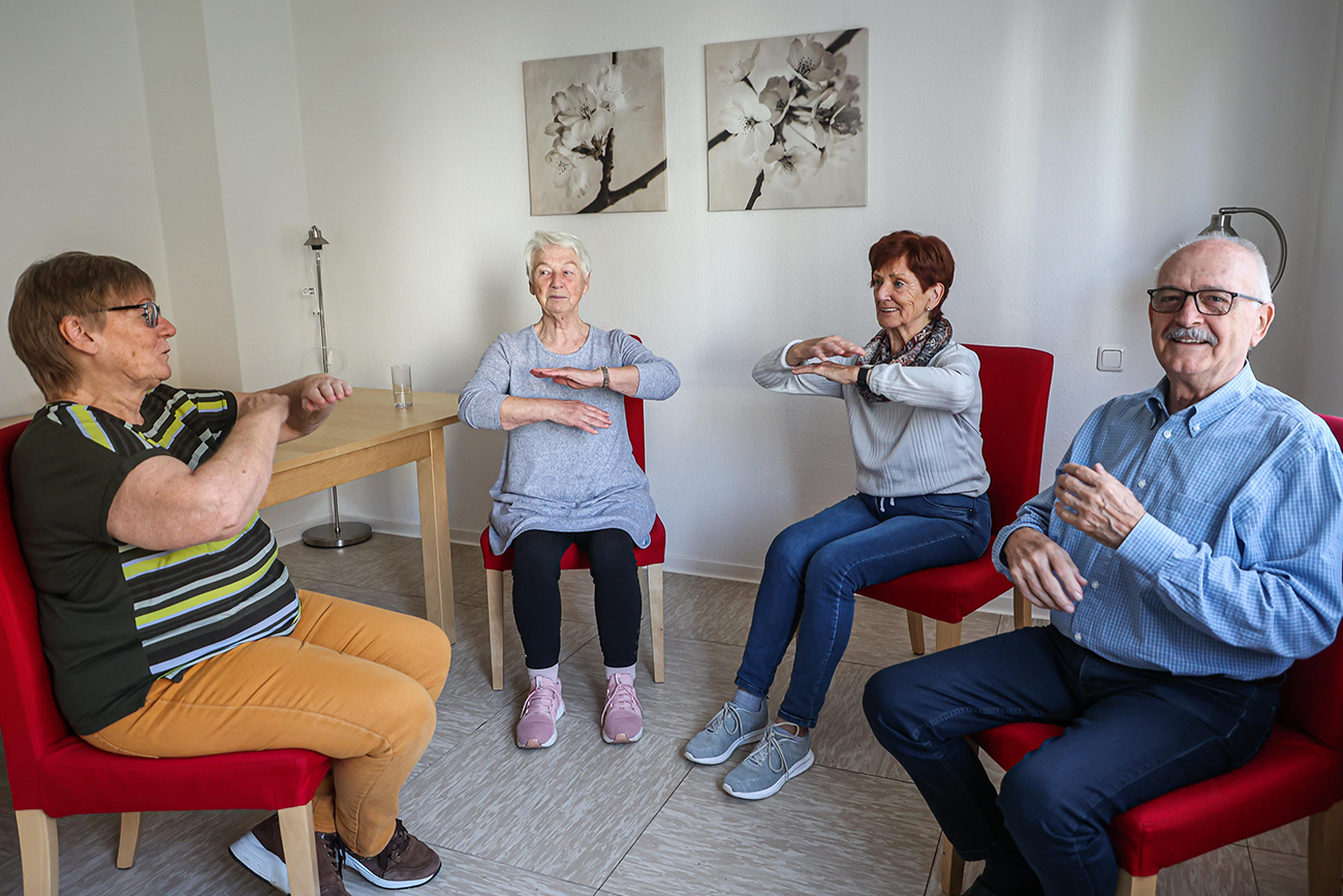 Mieter*innen machen Sport im Sitzen.