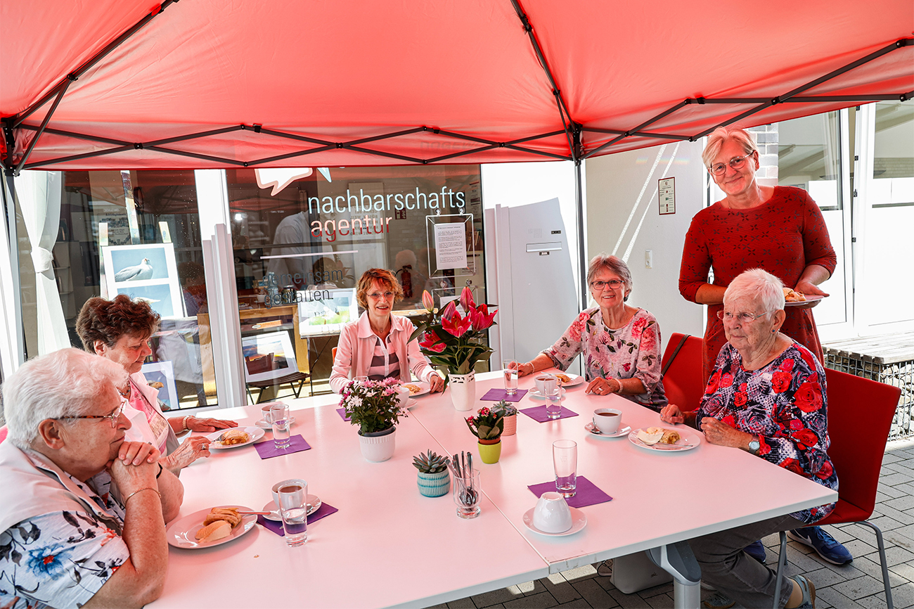 Ältere Damen sitzen gemütlich bei Kaffee und Kuchen bei der Nachbarschaftsagentur.