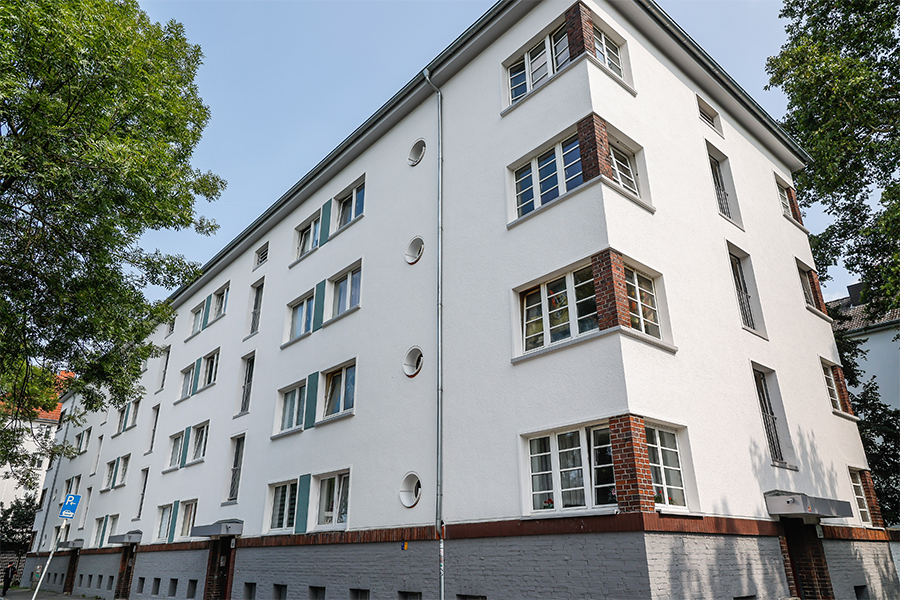 Weißes Mehrfamilienhaus mit modernem Steindekors.