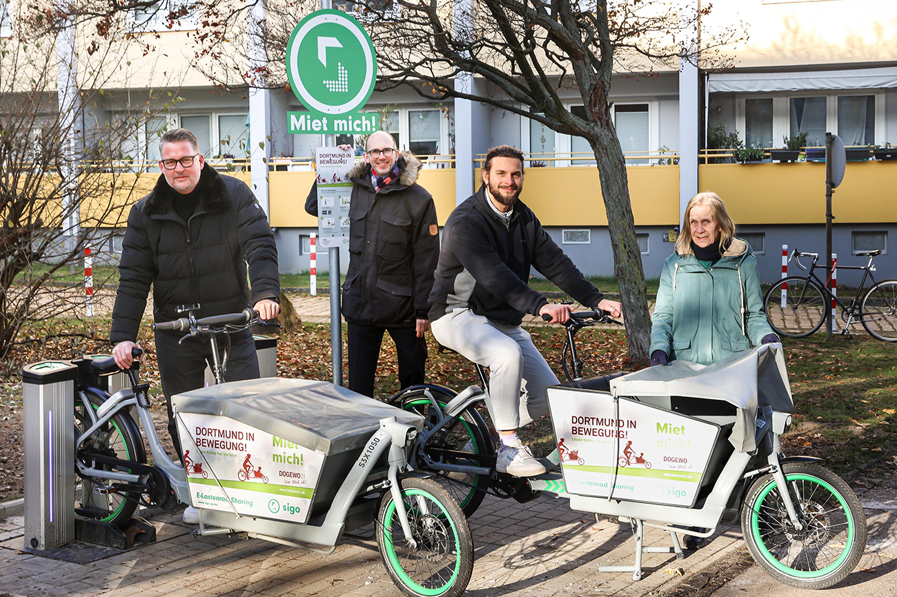 Eine Gruppe steht neben zwei E-Lastenfahrrädern.