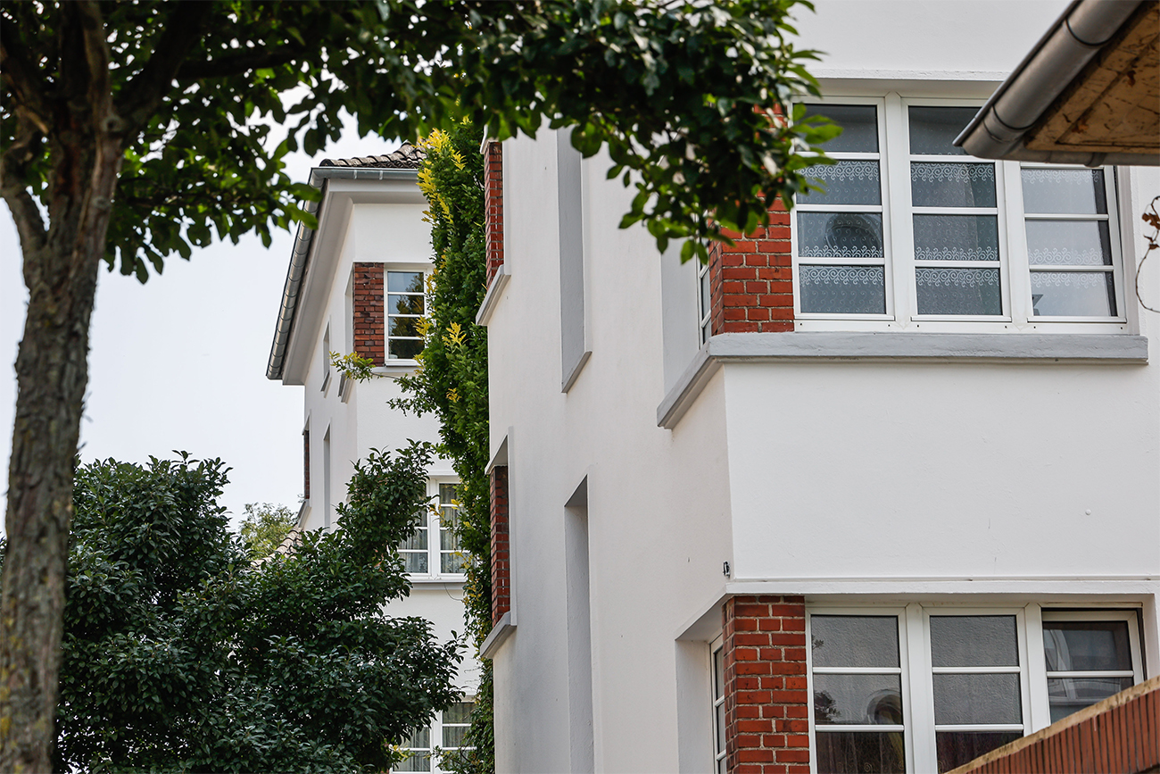 Modern sanierte Häuserfassade mit Steinkantenoptik.